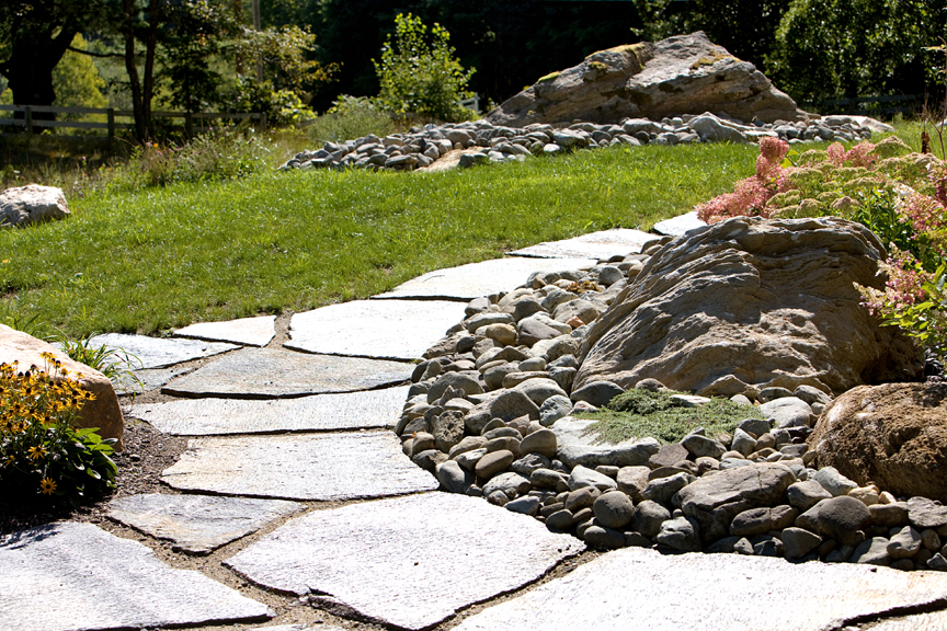 Goshen Stone walk to front door, Creeping Red Thyme in foreground, Hydrangea ‘Pinky Winky’ in background. Very large boulder left in place with river stone garden around it in far background. Photo: Craig Okerstrom-Lang