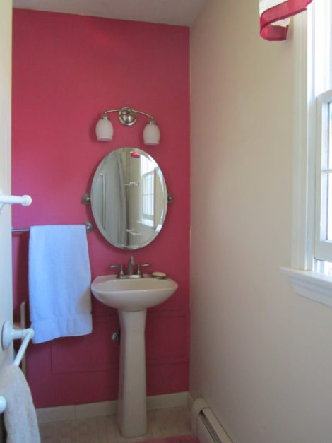 A powder room made to fit in a tiny L-shaped space.