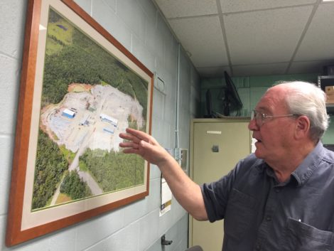 Ed Williams in his office, gesturing to an aerial view of the Williams Stone operations.