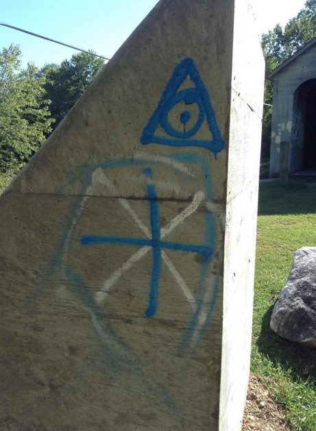 Symbols and messages were spray painted on the side of the monument. Photo: Thomas Reed