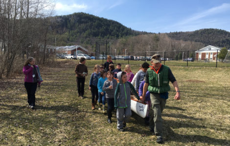 Alsop and his student crew guide his canoe down the path to Muddy Brook, with Monument Mountain in the background. Photo: David Scribner