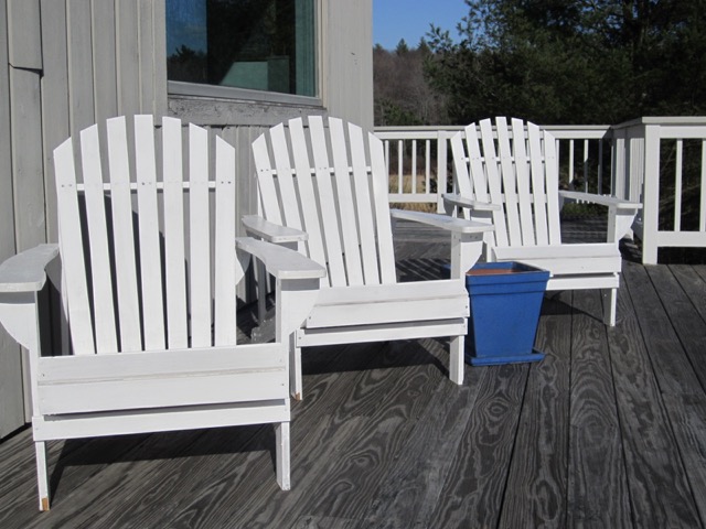 The single bright blue planter (waiting for the growing season) catches your attention among the bright white Adirondack chairs on this deck in Sandisfield.