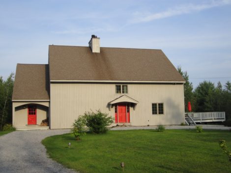 This large barn-like post and beam home in Sandisfield is oriented to the natural setting out back and to the side. The view from the road where one approaches would seem austere without the bright red doors which give a mere hint of the stylish and unique interior. Exterior stain, “Seagull Grey,” doors “Bonfire.”