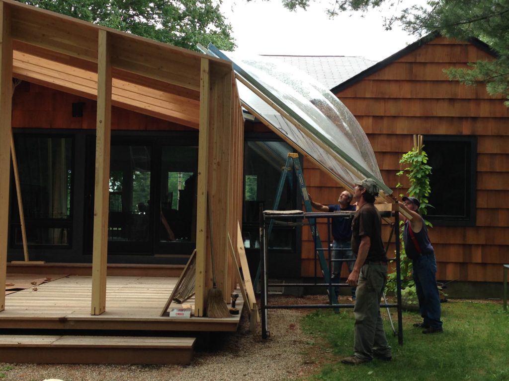 Muscling the skylights onto the roof – no crane or equipment was needed to raise them into place. - Photo: Michael Alper