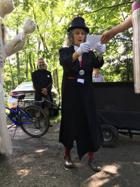 'Funeral director' Linda Putnam pauses to read before casting into the 'coffin' a sheet of paper depicting a 'dead' issue. Photo: Sugar Shack Alliance